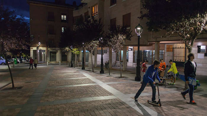 Children are playing in a square in the night under Philips lighting