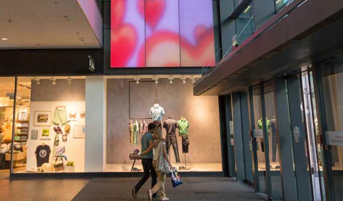 Một cặp đôi ngắm nhìn một bảng đèn Luminous Textile rực rỡ ở trung tâm mua sắm Centrum Galerie